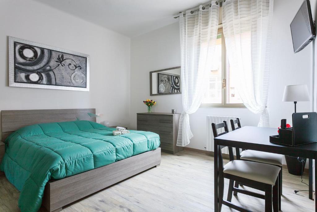 um quarto com uma cama, uma mesa e uma secretária em Il Filo di Arianna em Bolonha