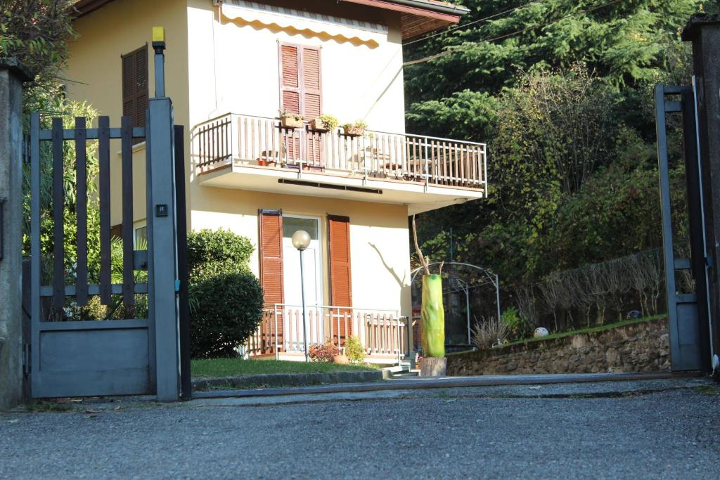 a white house with a balcony and a gate at Atelier 55 Casa arte e natura in Como