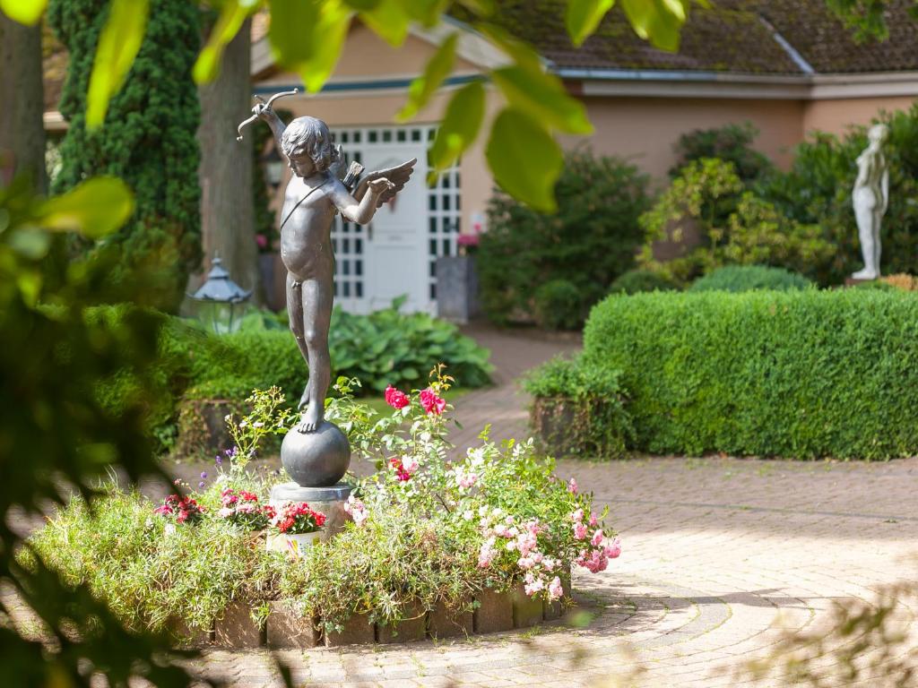 a statue of a girl playing a violin in a garden at Gästehaus Schloss Bothmer in Schwarmstedt