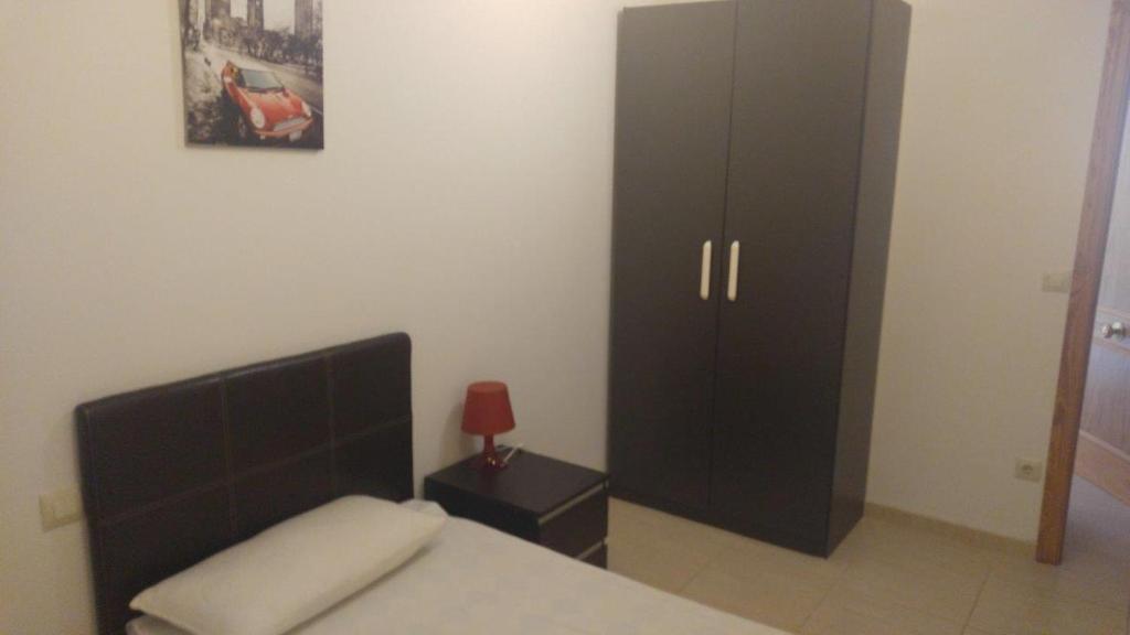 Un dormitorio con una cama y un armario negro. en LaFonda1-2-B, en Borja