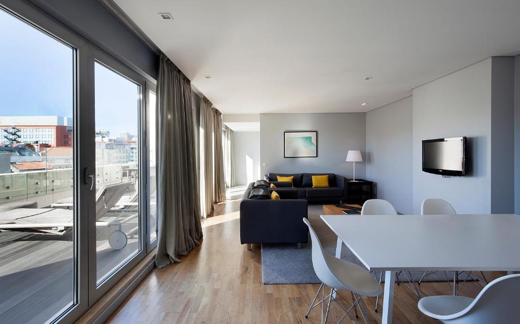 een woonkamer met een bank en een tafel met stoelen bij Altis Prime Hotel in Lissabon
