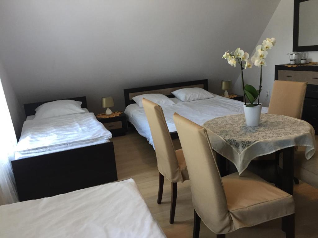 um quarto com duas camas e uma mesa e cadeiras em Biały Dwór em Kostrzyca