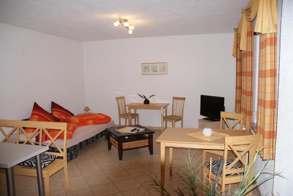 Schlafzimmer mit einem Bett, einem Tisch und Stühlen in der Unterkunft Pension am Radweg & Ristorante Juani in Wriezen