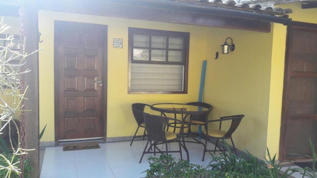 um pátio com uma mesa e cadeiras e uma porta em Seu cantinho em Geribá em Búzios