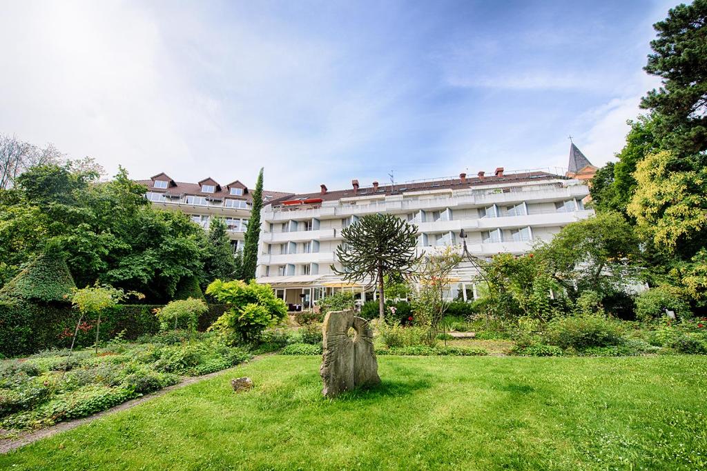 a large white building with a garden in front of it at ACHAT Hotel Bad Dürkheim in Bad Dürkheim