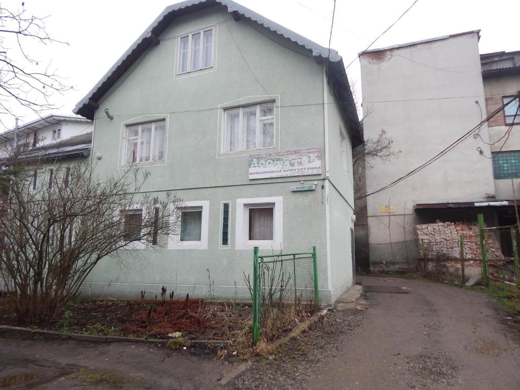ein weißes Haus mit einem Zaun davor in der Unterkunft Садиба Достаток in Kolomyja