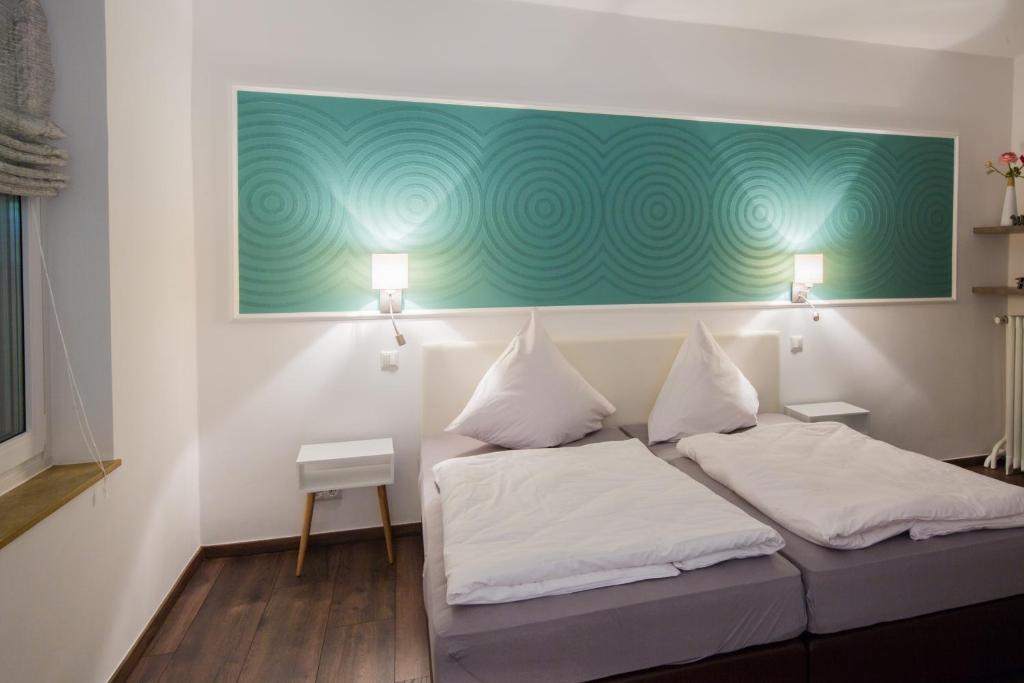 Habitación con 2 camas y una pintura verde en la pared. en Hotel Zur Alten Börse, en Osterholz-Scharmbeck