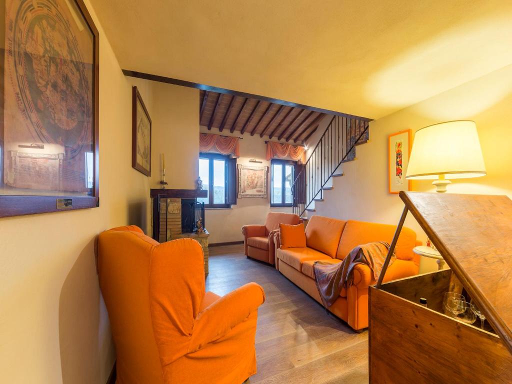ein Wohnzimmer mit orangefarbenen Stühlen und einem Sofa in der Unterkunft Casa Laura in San Gimignano
