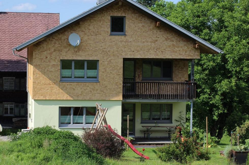 una casa con balcone e panchina nel cortile di Naturparadies Silvia ad Alberschwende