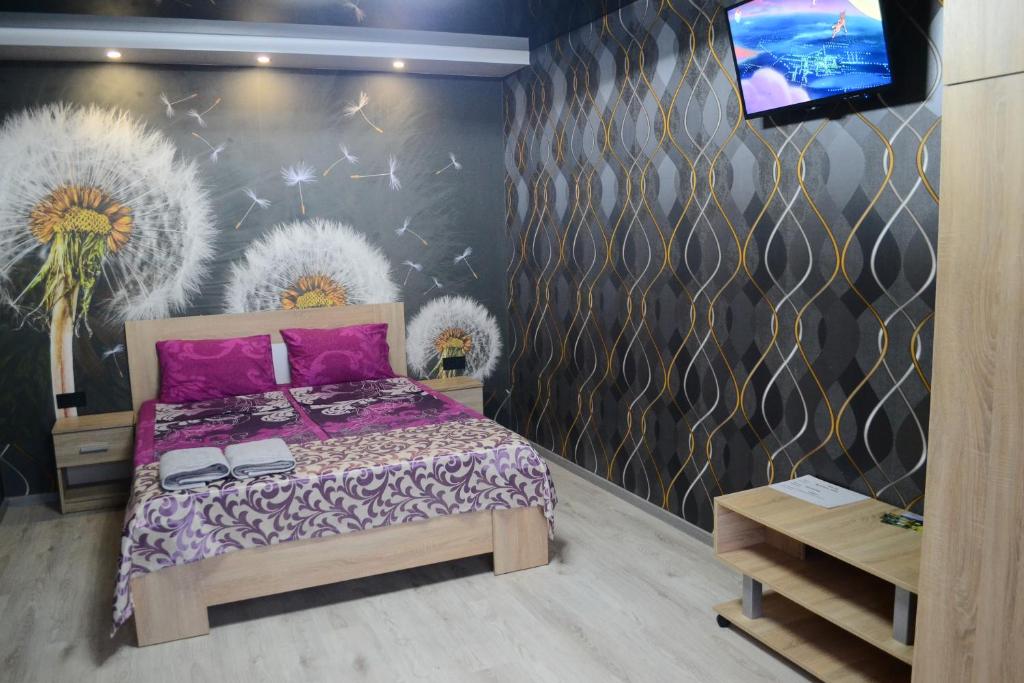 克里沃羅格的住宿－Apartmens on Geroiv ATO，一间卧室设有一张床和鲜花墙