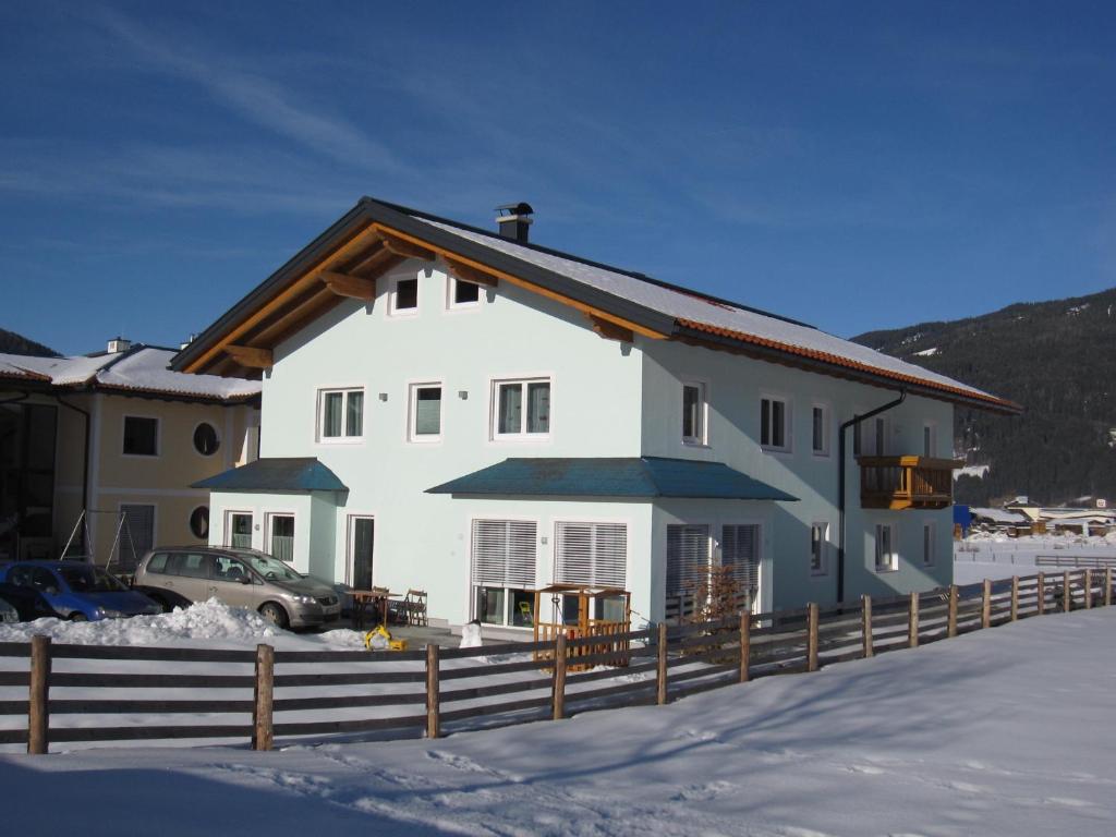 Haus Bergsonne في فلاخاو: بيت ابيض فيه سياج في الثلج