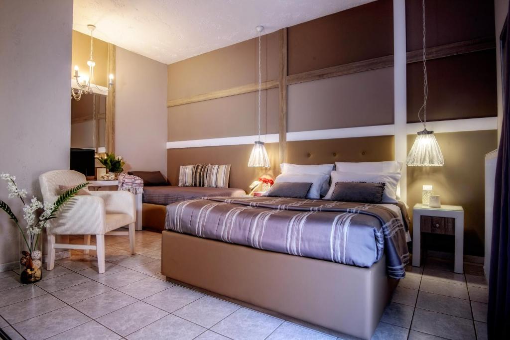 アムーダラ・イラクリオンにあるLino Mare Boutique Hotelのベッドルーム(大型ベッド1台付)、リビングルームが備わります。