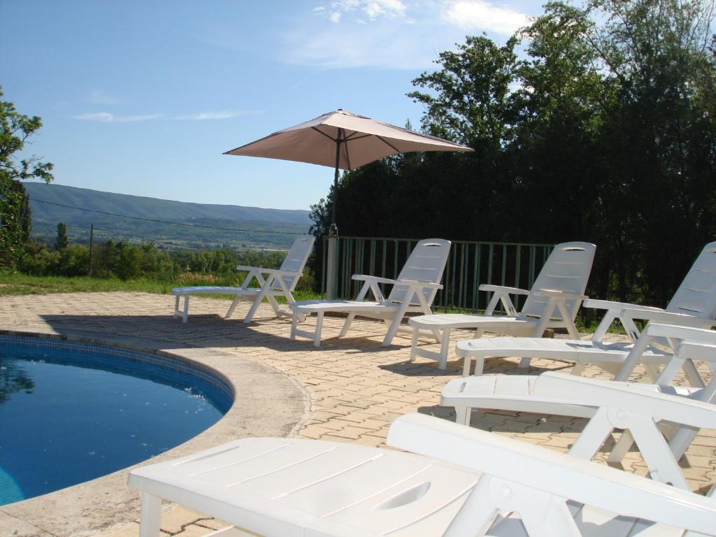 ボニューにあるhouse in the countryside in the luberon with beautiful view and private swimming-pool close to bonnieux in Provence - 8 personnesの白い椅子とパラソルのグループが並ぶプールサイド