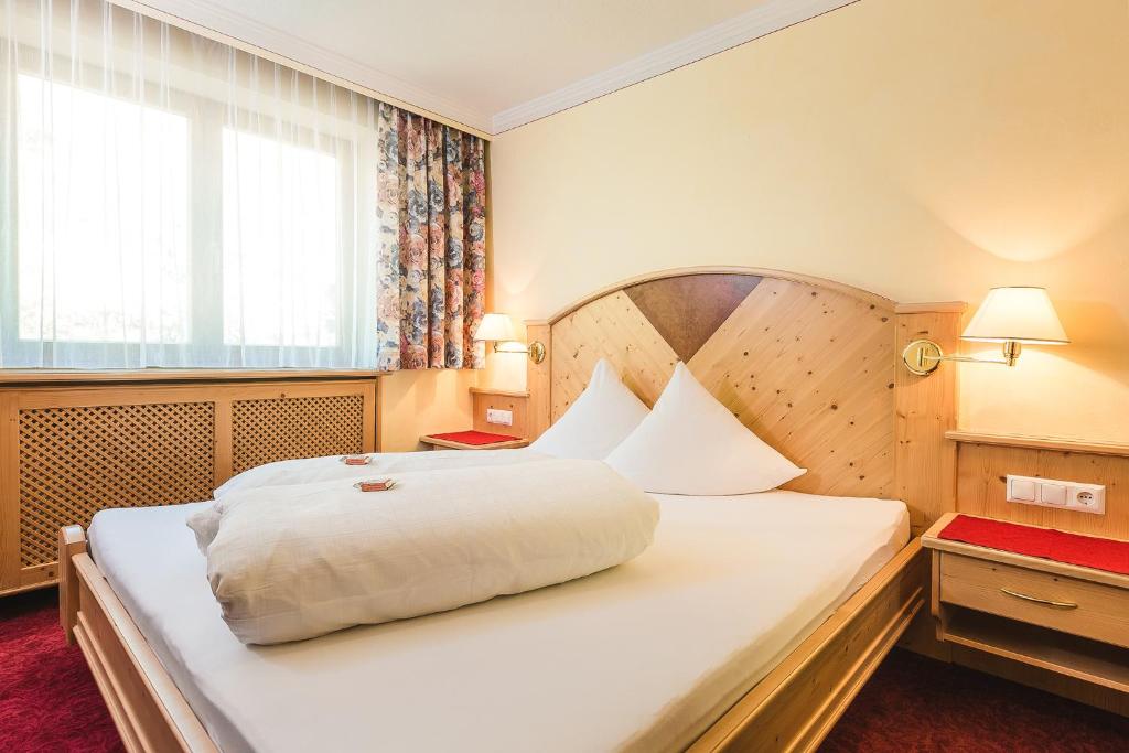 Postel nebo postele na pokoji v ubytování Hotel Garni Tirol