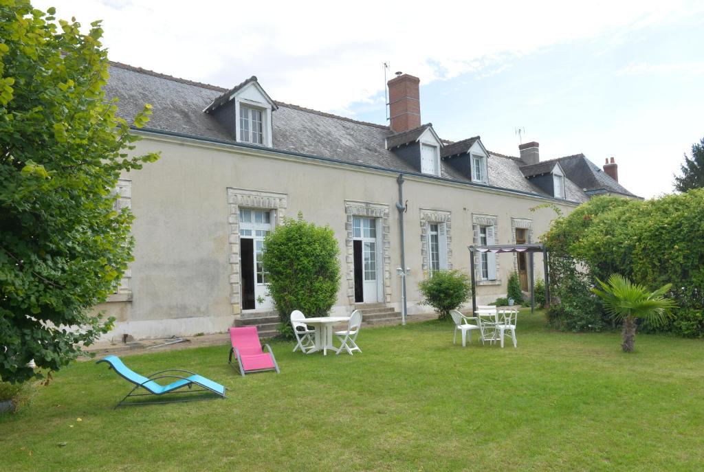 une maison avec des chaises et des tables dans la cour dans l'établissement Aurore de Beaufort, à Saint-Martin-le-Beau