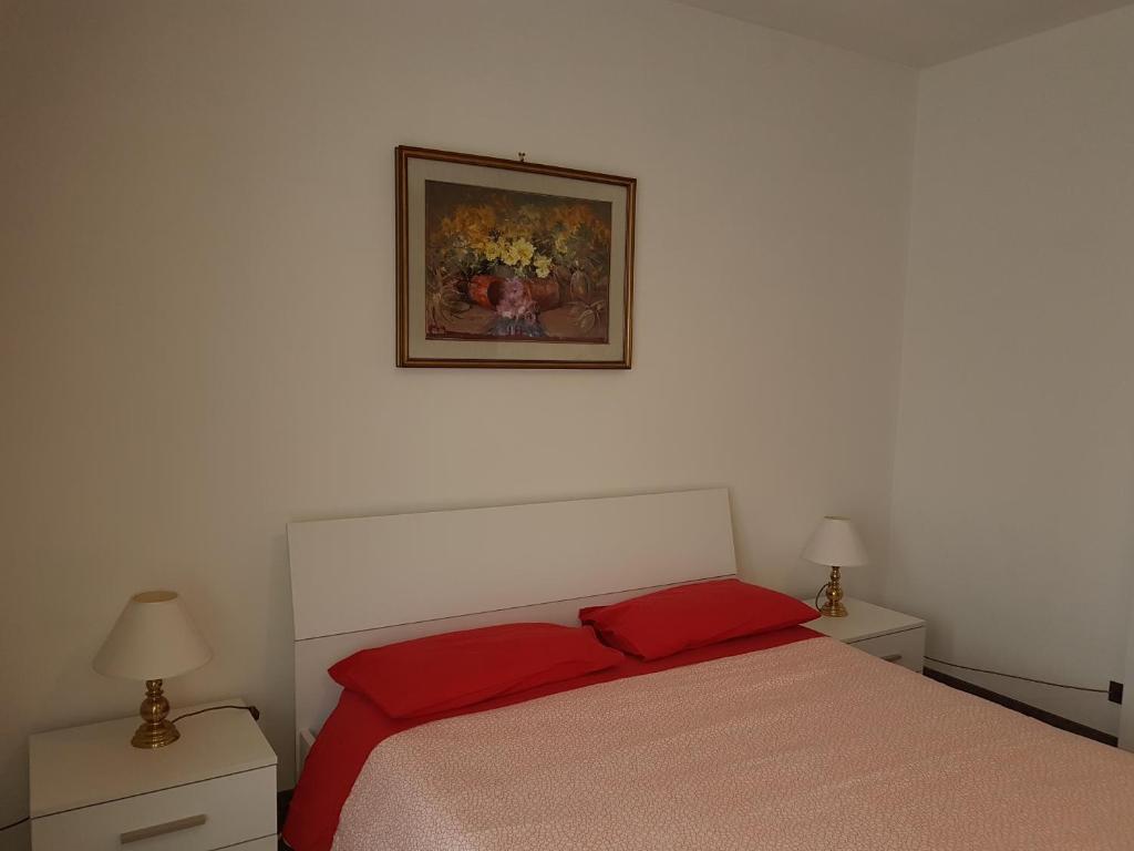 1 dormitorio con 1 cama y una foto en la pared en In centro a Saint Vincent, en Saint Vincent