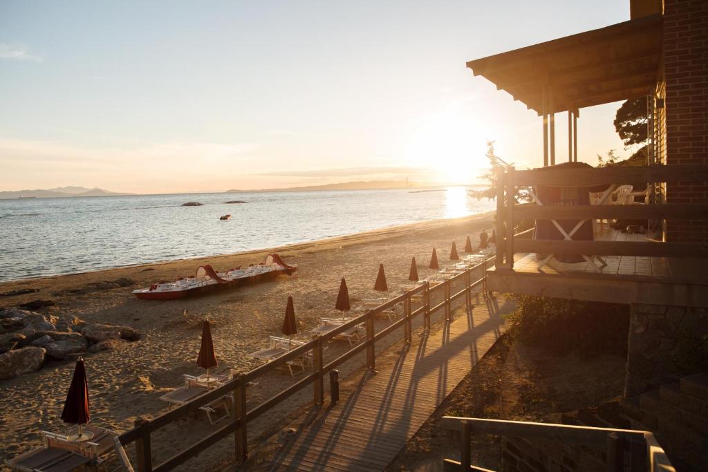 una spiaggia con persone e una barca sull'acqua di Golfo del Sole Hotel a Follonica