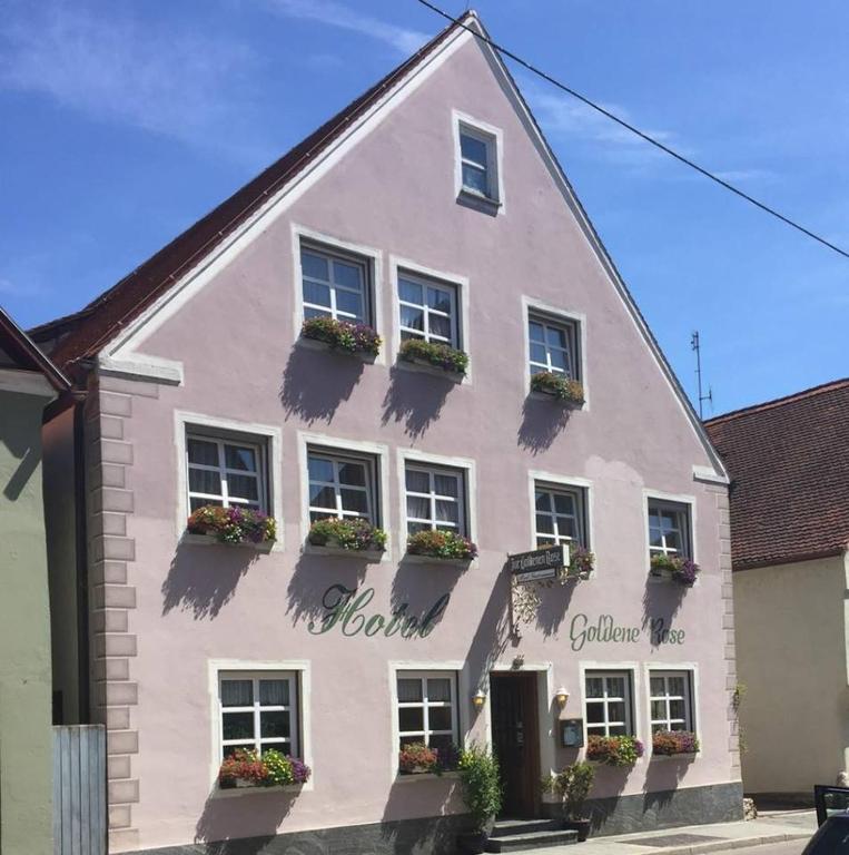 a white building with flower boxes on the windows at Hotel Goldene Rose in Nördlingen