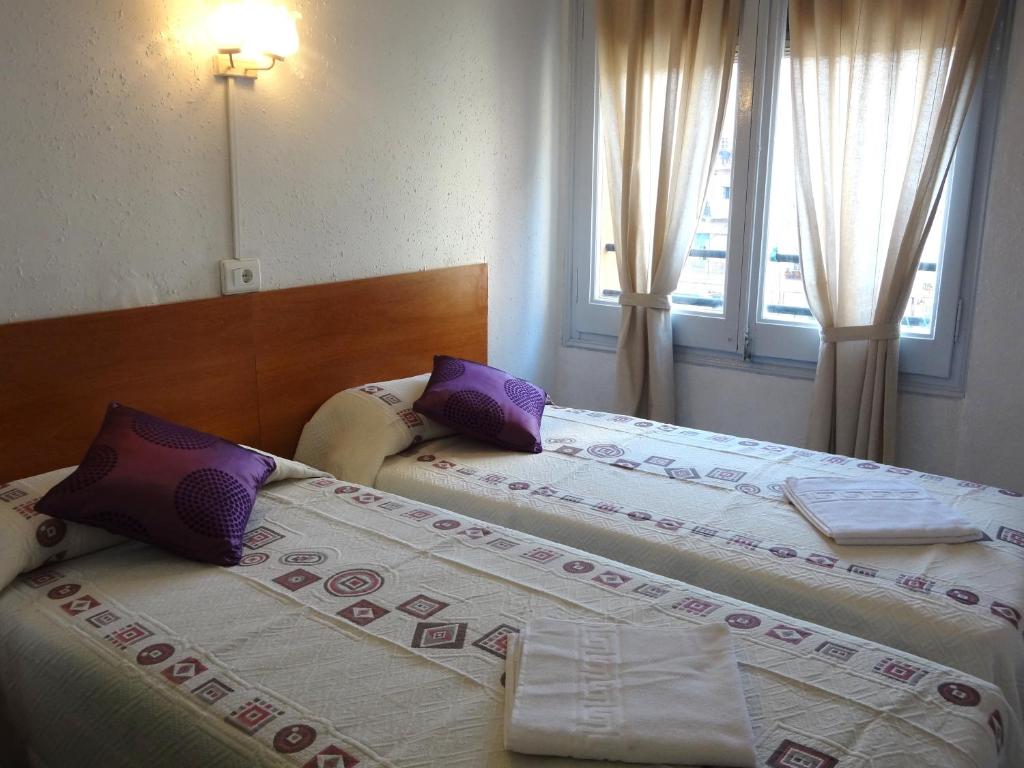 two beds sitting next to each other in a bedroom at Hostal Sant Carlo in Barcelona