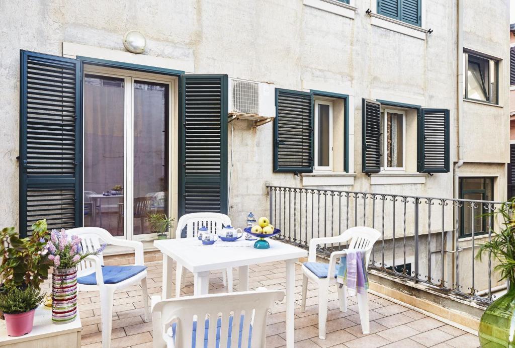 a white table and chairs on a balcony at Sabbia1 CaseSicule, Apartment in the City Center and beside the Main Square, Beach at 100 m, Wi-Fi in Pozzallo