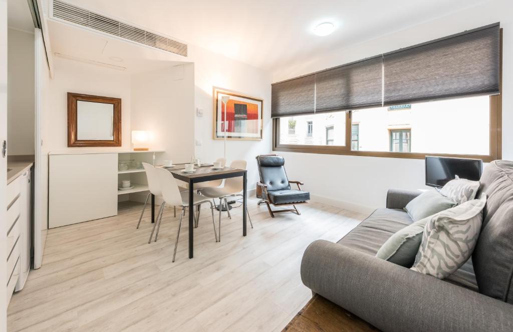ein Wohnzimmer mit einem Sofa und einem Tisch in der Unterkunft Recoletos in Madrid
