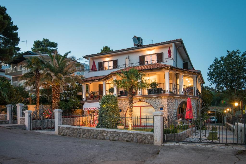 a large house with a fence in front of it at Guesthouse Villa Maria in Malinska