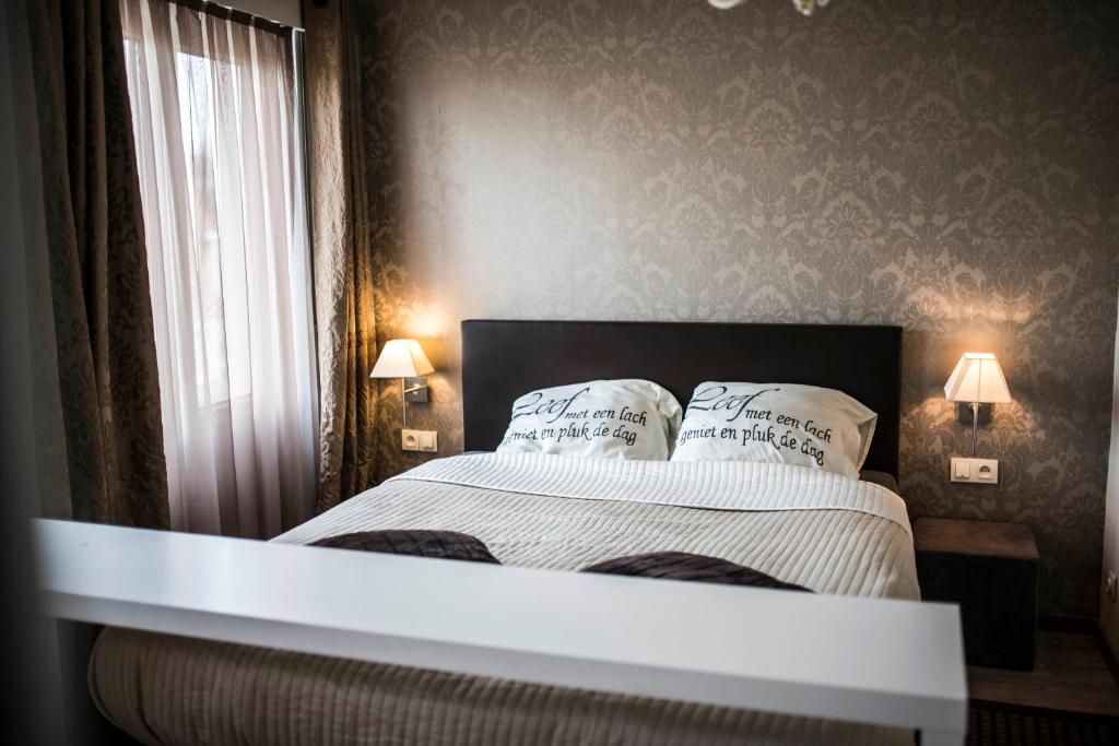 una camera con un letto con due cuscini sopra di B&B A Dream City spa & Massages a Bruges