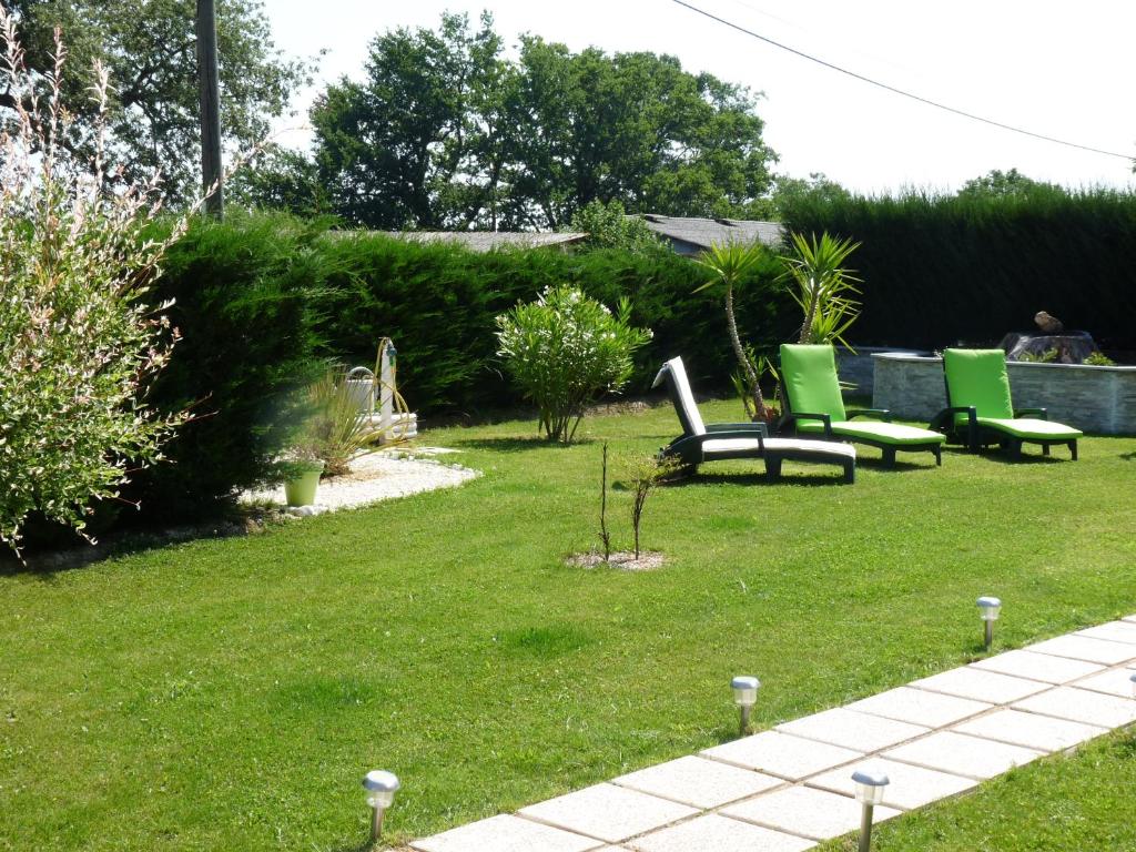 two green chairs sitting in a yard with grass at Chambre Bel Air in Pimbo