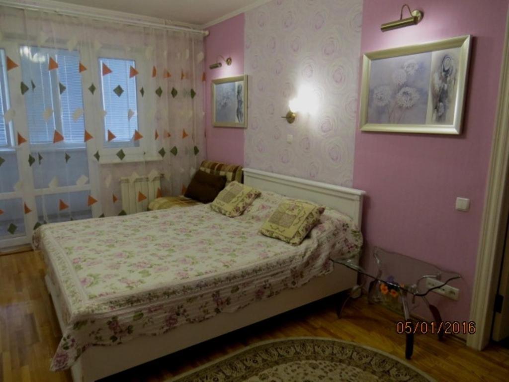 スームィにあるLushpy Apartmentのピンクの壁、ベッド1台付きのベッドルーム1室