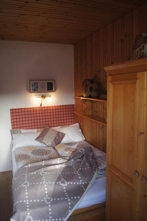 DaianoにあるCasa dei Lariciのベッドルーム1室(赤いヘッドボード付きのベッド1台付)