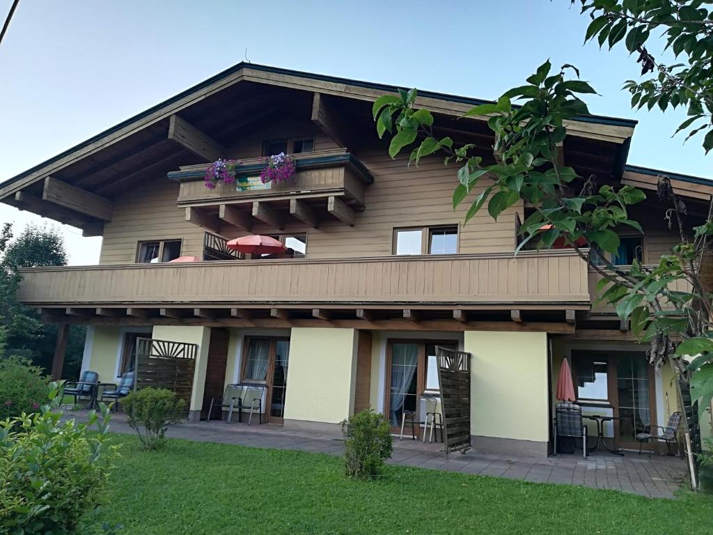 uma casa com uma varanda com mesas e cadeiras em Haus Imbachhorn em Zell am See