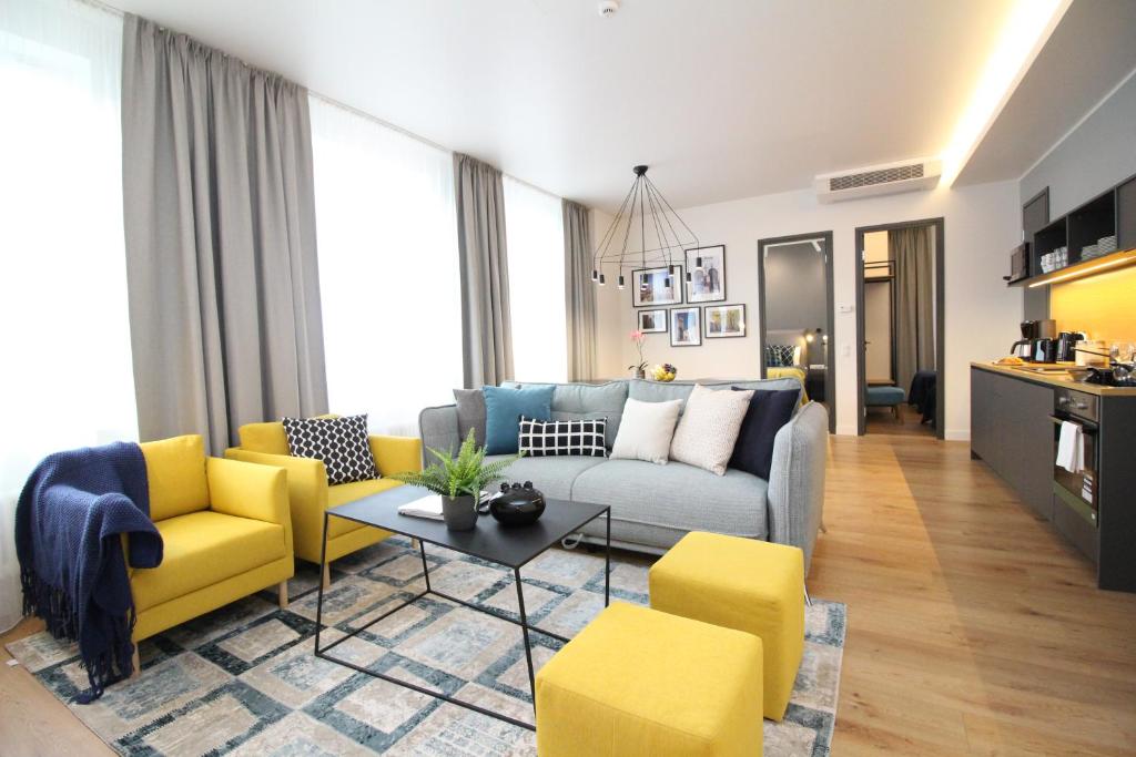 a living room with a couch and yellow chairs at Tallinn City Apartments Old Town Suites in Tallinn