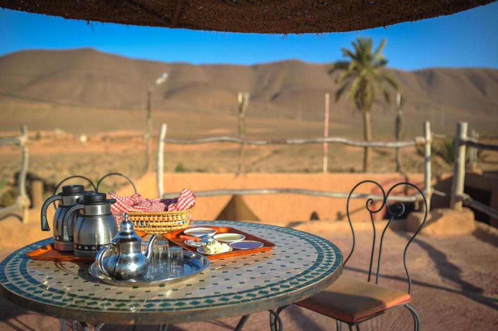 a table with a tea set on it in the desert at Tarmguist in Tighmert