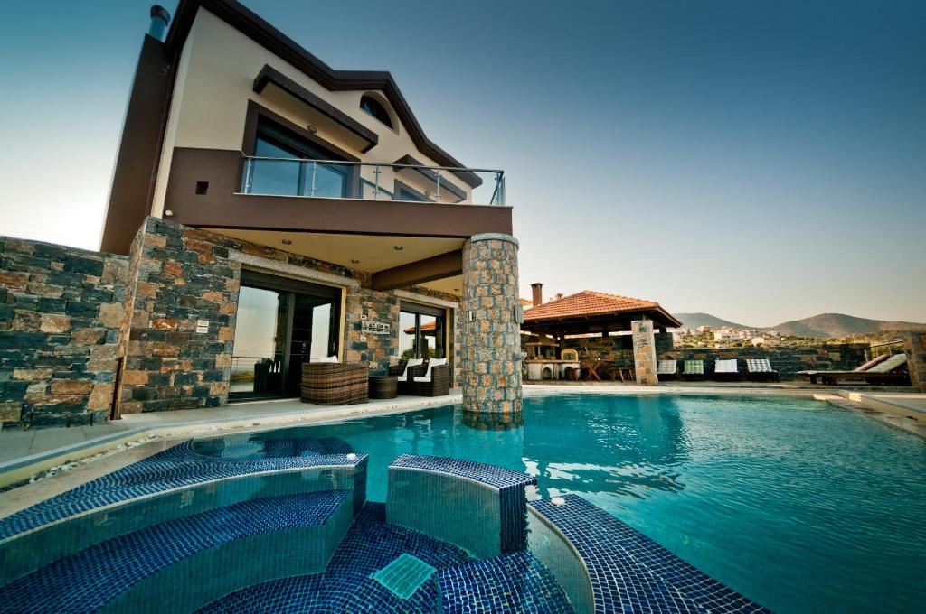 a villa with a swimming pool and a house at Villa St. Nicolas & Theano in Agios Nikolaos
