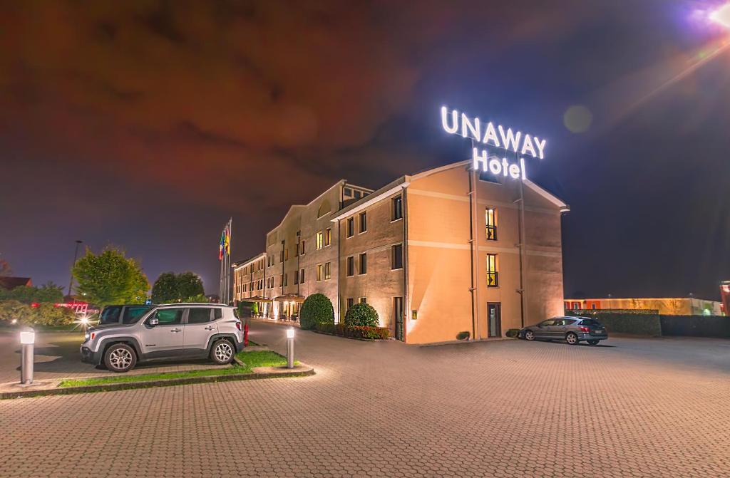 a building with a car parked in a parking lot at UNAWAY Hotel Occhiobello in Occhiobello