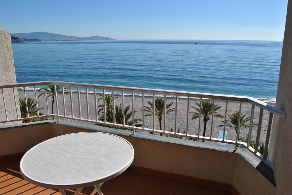 uma varanda com uma mesa e vista para o oceano em Bertur Tao em Almuñécar