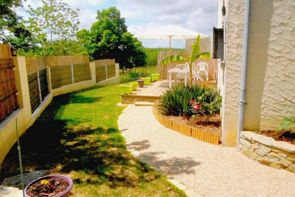 a garden with a table and chairs and a fence at Chambres d'Hôtes Le Clos du Murier in Villefranche-de-Rouergue