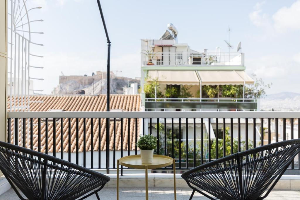 a patio with two chairs and a table on a balcony at Central Cozy Apartments in Plaka by UPSTREET in Athens