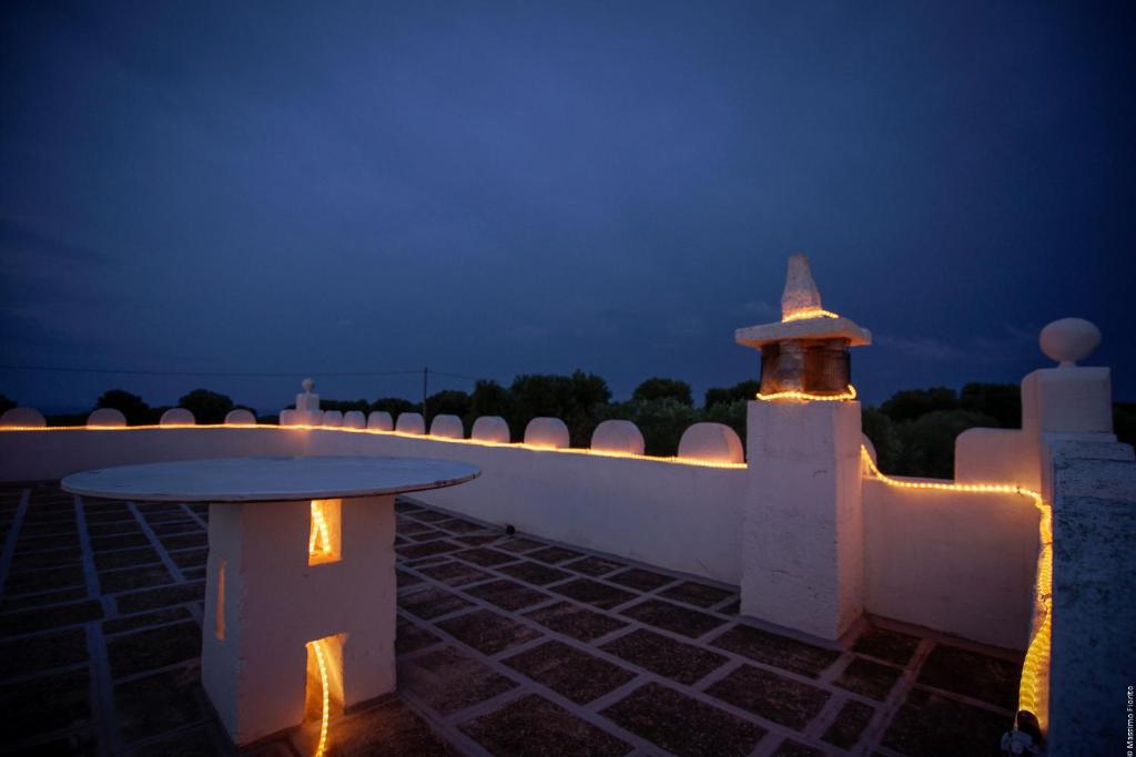 a patio with a table and lights at night at Case d'Artista in Savelletri di Fasano