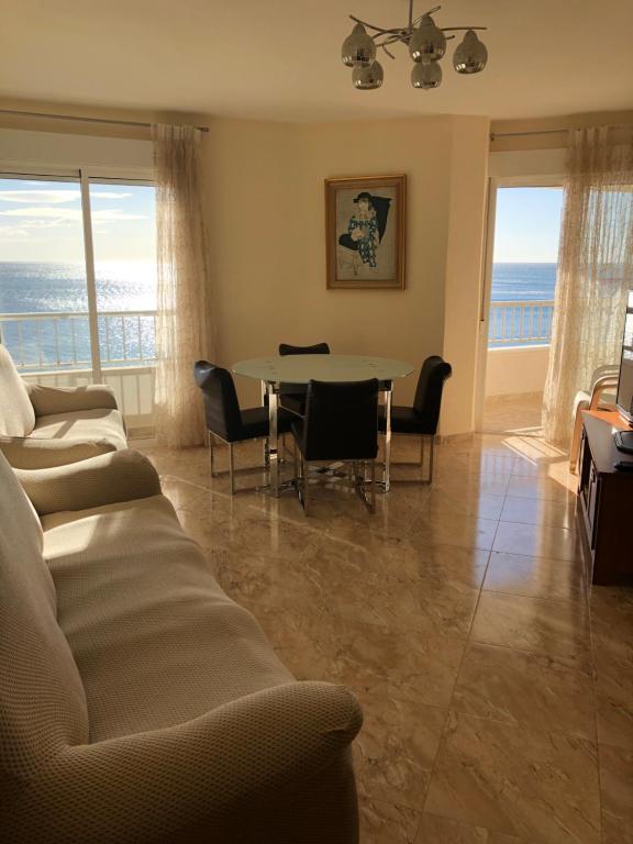 a living room with a couch and a table with chairs at Playa Los Locos - Coloso in Torrevieja