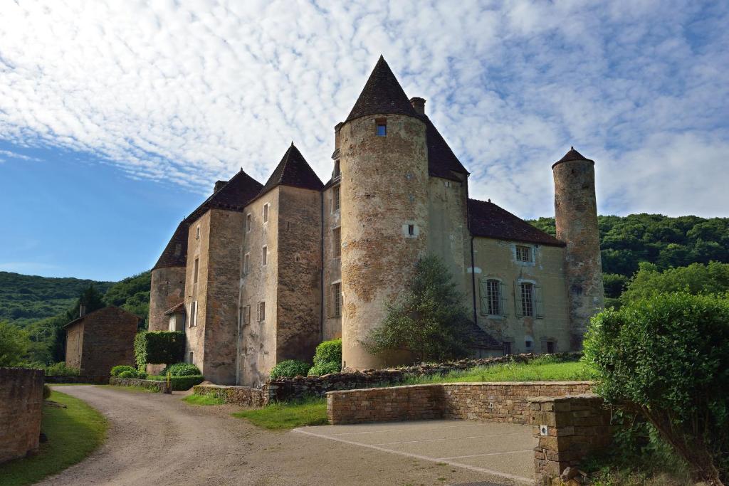 un viejo castillo con tres torres en un camino de tierra en Chateau de Balleure, en Étrigny