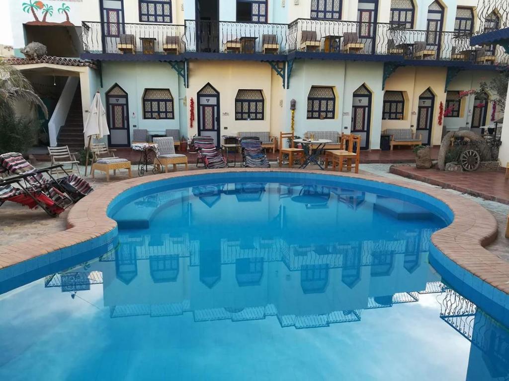 una gran piscina frente a una casa con patio en Monica Hotel en Dahab