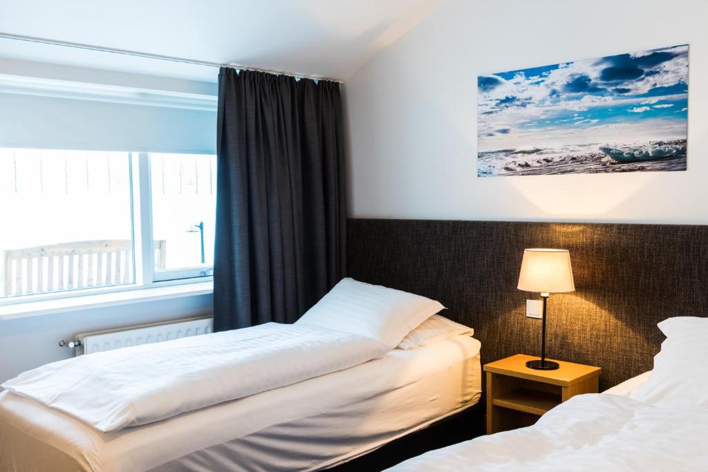 Cette chambre comprend 2 lits et une fenêtre. dans l'établissement Litli Geysir Hotel, à Haukadalur