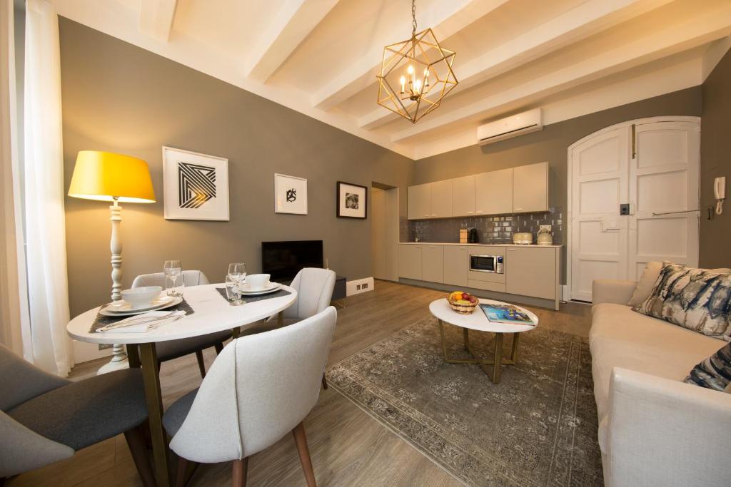 a living room with a table and chairs and a couch at Merchant Street Apartment in Valletta