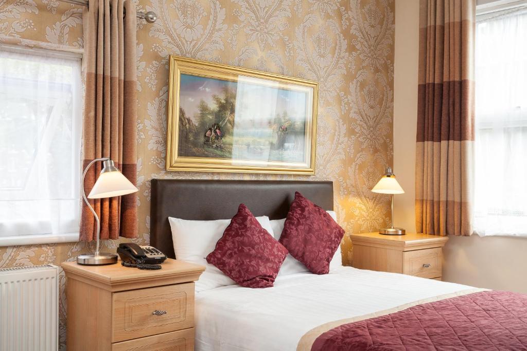 ein Schlafzimmer mit einem Bett und einem Bild an der Wand in der Unterkunft Roseview Alexandra Palace Hotel in London