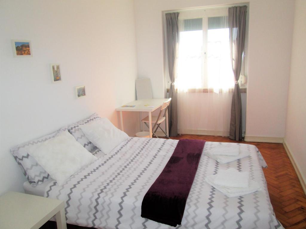 里斯本的住宿－Belém Cozy Bedroom，一间卧室配有一张床、一张书桌和一个窗户。