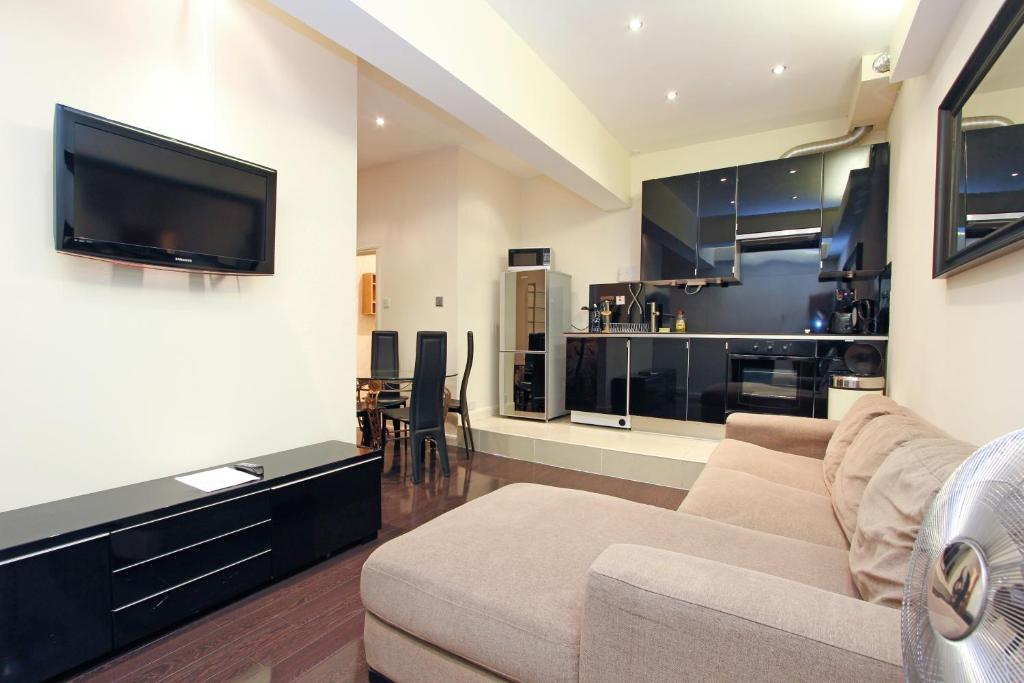 a living room with a couch and a flat screen tv at London Central Apartments in London