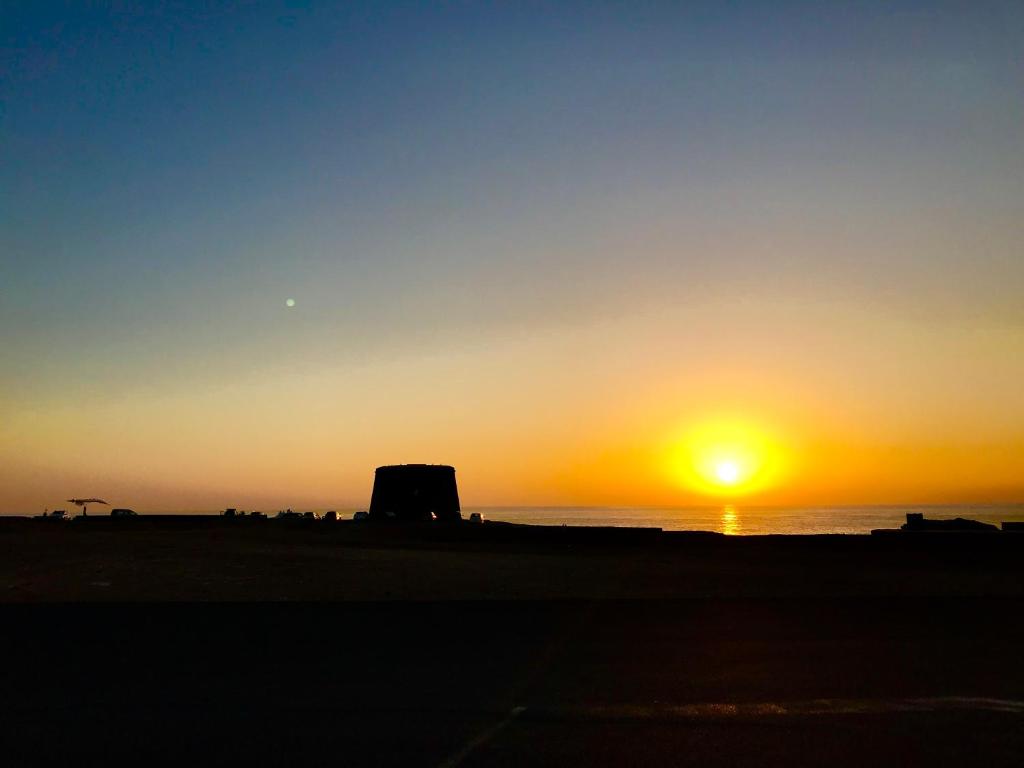 zachód słońca na plaży z zachodzącym słońcem w obiekcie Casa Sunshine Cotillo Mar w mieście Cotillo