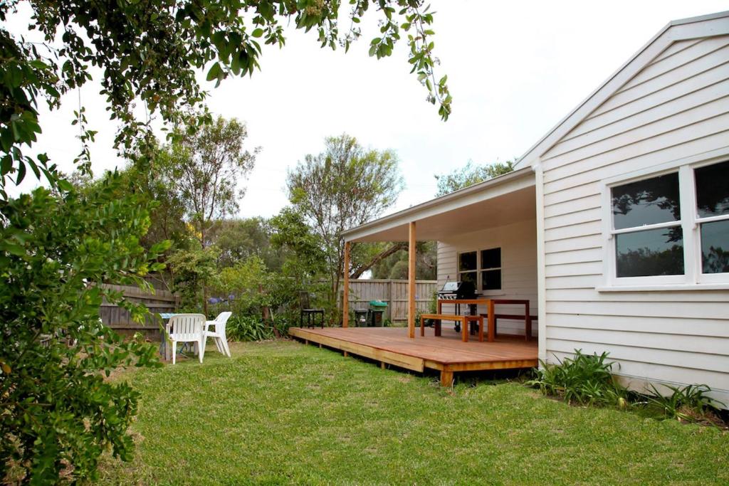 a backyard with a wooden deck next to a house at Sorrento Beach Cottages No.1 - in the heart of Sorrento in Sorrento