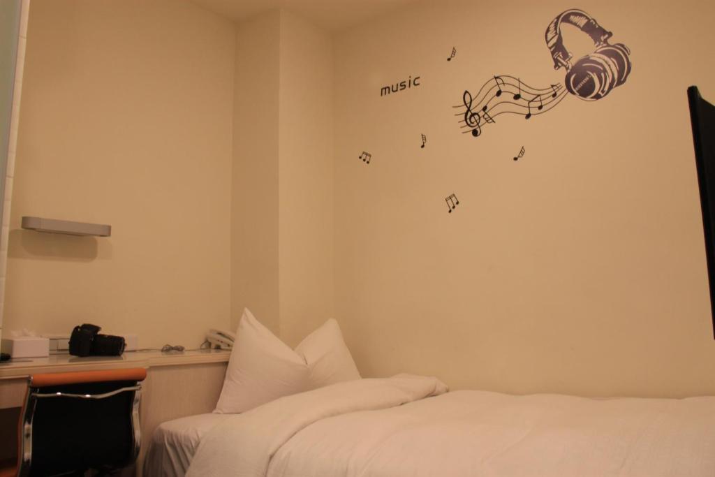 a hotel room with a bed and a music sign on the wall at Century Hotel in Kaohsiung